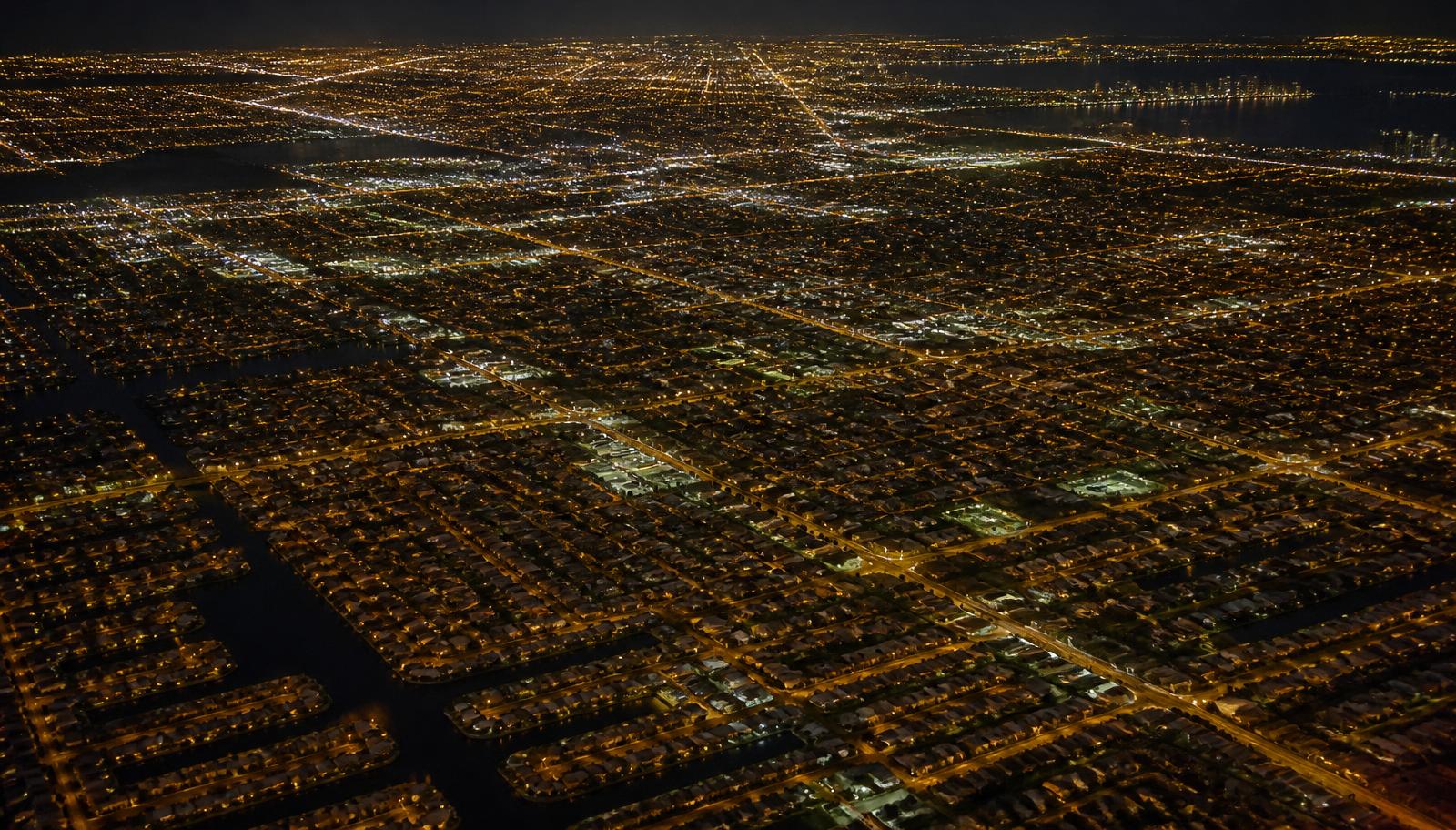 Aerial night view of a dense Miami street grid illustrating the geographic coverage a pest control service route follows